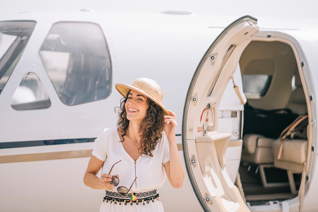 Pretty woman lowers an outdoor airplane.